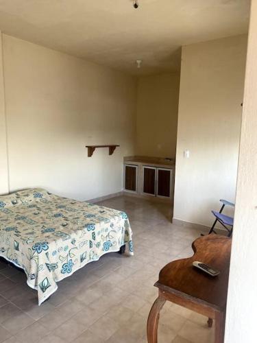 a bedroom with a bed and a table in a room at Bungalow at the beach all services in Rincon de Guayabitos