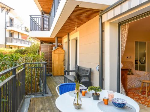 un patio avec une table et des chaises sur un balcon dans l'établissement Apartment Couleurs Tchanquées-1 by Interhome, à Arcachon