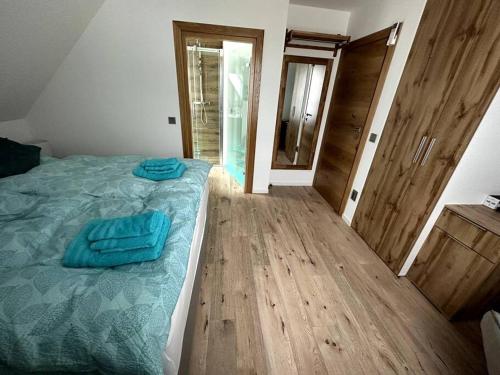 1 dormitorio con 1 cama con sábanas azules y suelo de madera en Haus an der Sieber Zimmer 5, en Herzberg am Harz