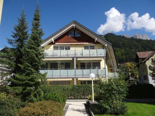 une maison avec un balcon et un arbre dans l'établissement Apartment Bellevue-Park B 138 by Interhome, à Engelberg