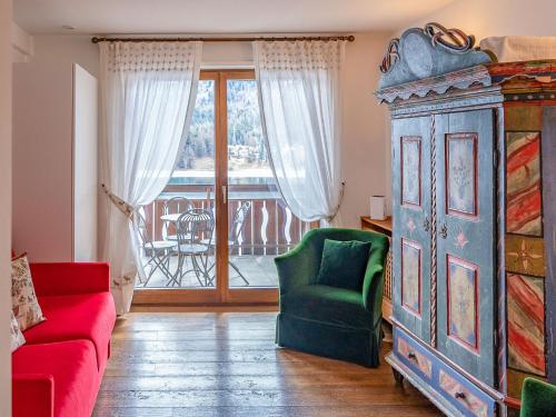 ein Wohnzimmer mit einem Sofa, einem Schrank und einem Balkon in der Unterkunft Apartment Chesa Sonnalpine B 48-5 by Interhome in St. Moritz