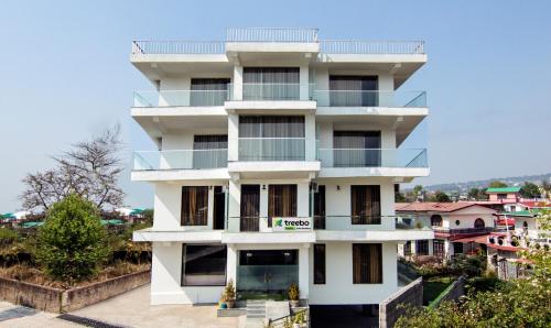 a white building with balconies on the side of it at Treebo Trend Ortus Residency in Dharamshala