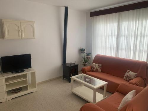 UNIFAMILIAR SIERRA DE CADIZ في البوسكي: غرفة معيشة مع أريكة وتلفزيون