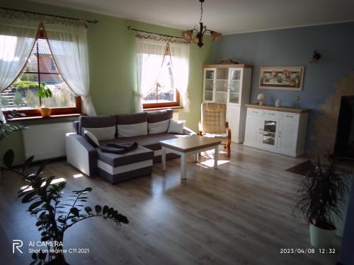 a living room with a couch and a table at Pokoje do Wynajęcia - Sen na Mazurach in Mikołajki