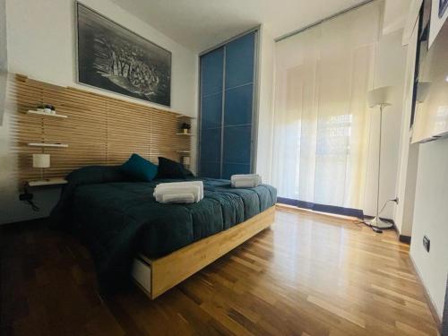 een slaapkamer met een groot bed en een houten vloer bij CasaPratti Pescara centro in Pescara