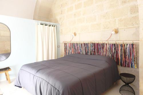 een slaapkamer met een bed en een bakstenen muur bij Sottano del Mastro Central Apartment in Corato