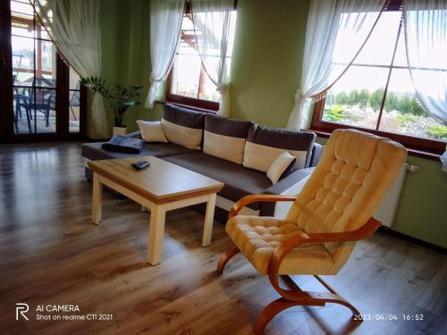 a living room with a couch and a coffee table at Pokoje do Wynajęcia - Sen na Mazurach in Mikołajki