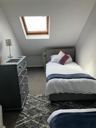 a bedroom with a bed and a dresser and a window at Causeway Street Holiday House Self Catering-Portrush in Portrush