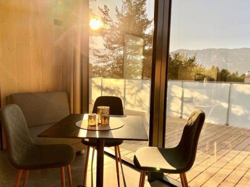 a table and chairs in a room with a balcony at Chalet PANORAMA Lodge by Interhome in Imst