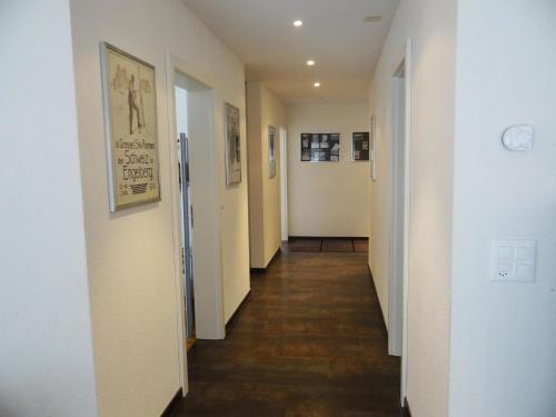 einen langen Flur mit weißen Wänden und Holzböden in der Unterkunft Apartment Bellevue-Park B 145 by Interhome in Engelberg