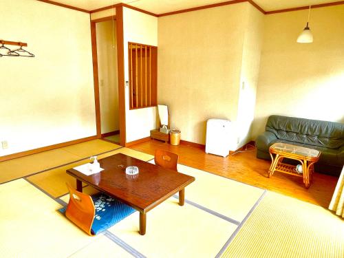 a living room with a table and a couch at タートルハウス in Shimoda