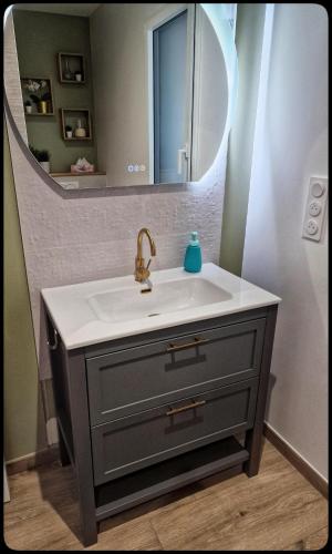 une salle de bain avec un lavabo et un miroir dans l'établissement Chambre proche Puy du fou entrée indépendante, Encas du matin Offert, à Bazoges-en-Paillers