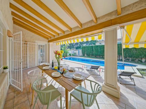 una sala da pranzo con tavolo, sedie e piscina di Holiday Home La Sal by Interhome a Moraira