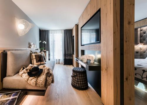 un soggiorno con un divano e una TV di Majestic Hotel a Madonna di Campiglio