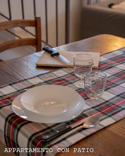 a wooden table with a plate and glasses on it at Fienile Chiaramada in Belluno