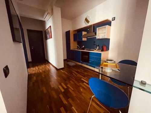 a kitchen with blue cabinets and a blue chair at CasaPratti Pescara centro in Pescara