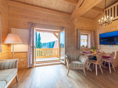 a living room with a dining room table and a large window at Holiday Home Chalet Toni mit Sauna by Interhome in Spiegelau