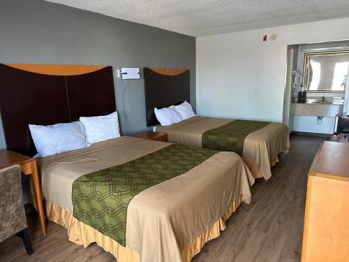 a hotel room with two beds and a table at Rodeway Inn in Hopkinsville