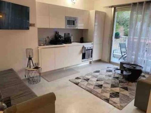 a living room with a couch and a kitchen at Studio Residence de la Plage, au bord de la mer in Menton