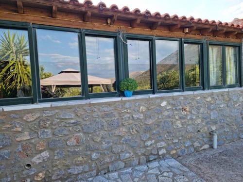 a stone wall with windows with a view of a mountain at Petra & Elia in Oítilon