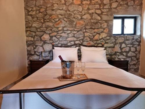 a bed with a table with glasses on it at Petra kai Elia in Oitylo