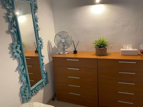 een dressoir met een ventilator en een spiegel in een kamer bij Puskas Apartman in Costa de Antigua