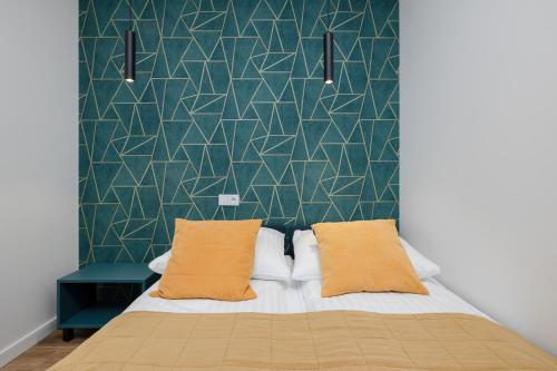 ein Schlafzimmer mit einem Bett und einer grünen Wand in der Unterkunft Apartament LAZUROWY Bridge Apartments & Spa z basenem Dziwnów EPapartamenty in Dziwnów