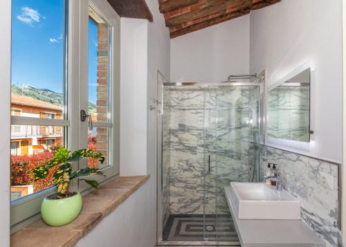 a bathroom with a shower and a sink and a window at Casale1918 in Pietrasanta