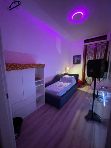 1 dormitorio con cama y luz morada en R’nB&B, en Milán