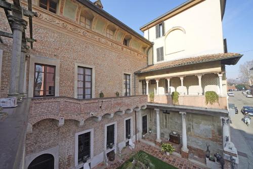 um antigo edifício de tijolos com uma varanda numa rua em Foresteria Palazzo Guazzoni Zaccaria em Cremona