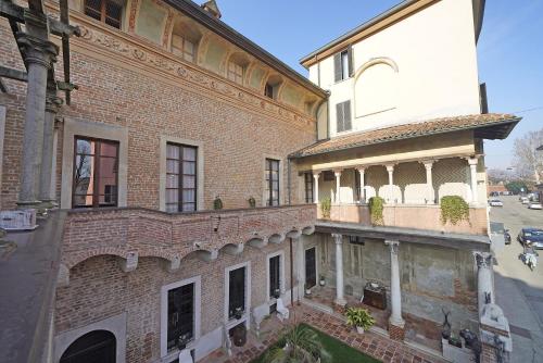 an old brick building with a balcony on a street at Foresteria Palazzo Guazzoni Zaccaria in Cremona