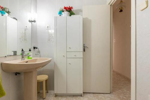 baño con lavabo y armario blanco en Mi descanso, en Madrid