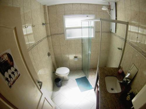 a small bathroom with a toilet and a shower at Joshua Tree Hostel - Curitiba in Curitiba