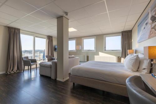 カラントスウオーフにあるFletcher Badhotel Callantsoogのベッド、デスク、椅子が備わるホテルルームです。