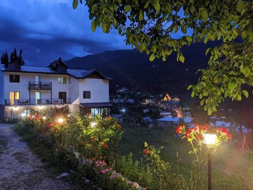 una casa con luci in un giardino di notte di Roza's guest house a Mestia