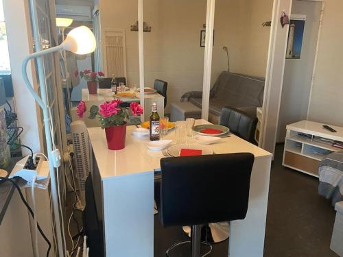 - une cuisine et un salon avec une table et une bouteille de vin dans l'établissement Escale Paradisiaque à Sète, à Sète