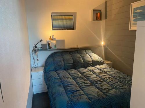 een slaapkamer met een bed in een kamer met een lamp bij Escale Paradisiaque à Sète in Sète