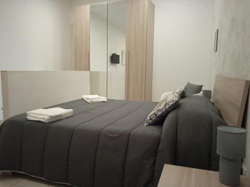 a bedroom with a black bed with towels on it at Case Serena vacanze relax in Catania