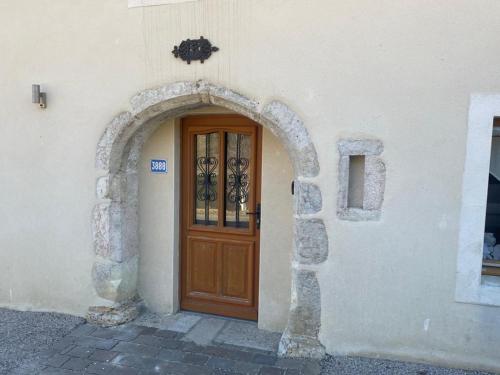 - une entrée pour un bâtiment avec une porte en bois dans l'établissement Au cœur du massif jurassien, aux Rousses