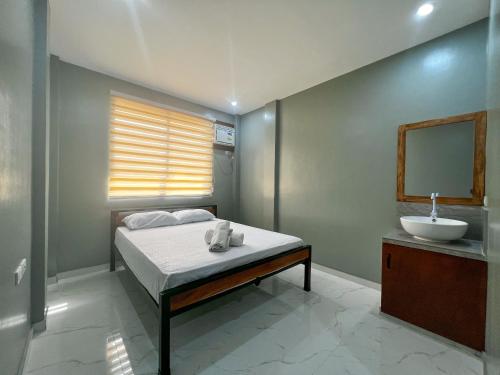 een slaapkamer met een bed met een wastafel en een spiegel bij Monati Hostel Panglao in Panglao
