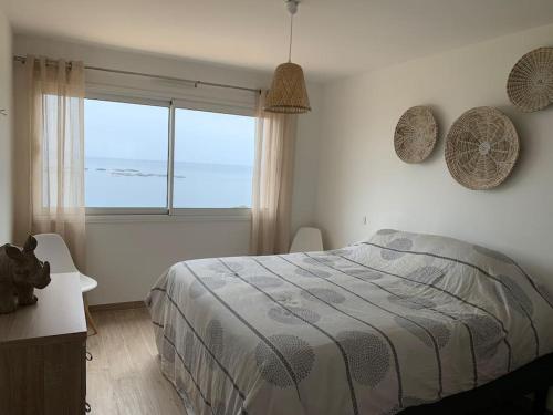 sypialnia z łóżkiem i dużym oknem w obiekcie Ajaccio maison bord de mer dans résidence avec piscine w Ajaccio