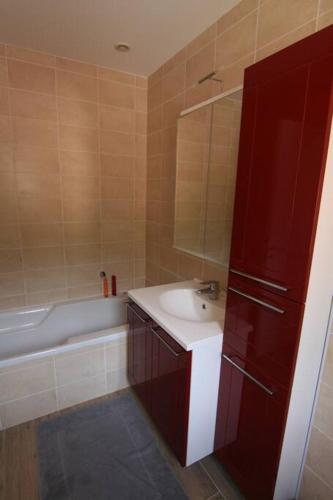 une salle de bain avec un lavabo et une baignoire dans l'établissement Ajaccio maison bord de mer dans résidence avec piscine, à Ajaccio