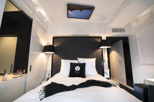 a hotel room with a bed with a black pillow on it at Vertigo Hotel, By Marriott, a Member of Design Hotels in Dijon