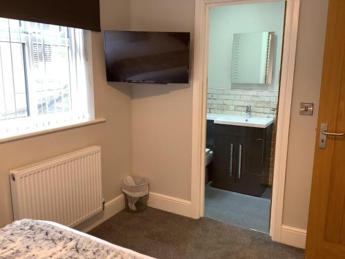 Baño pequeño con lavabo y espejo en Jeffersons Hotel & Serviced Apartments en Barrow in Furness