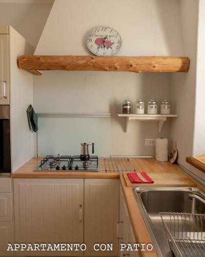 a kitchen with a sink and a clock on the wall at Fienile Chiaramada in Belluno