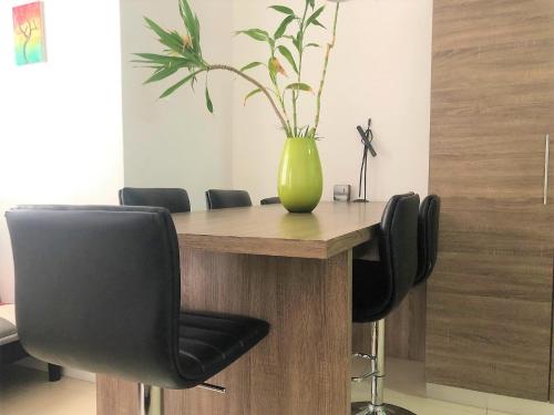 a table with a green vase on top of it at Pereybere Holiday Apartment in Pereybere