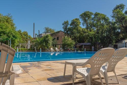 una mesa y sillas junto a una piscina en El Molino - Complejo Turístisco en Victoria