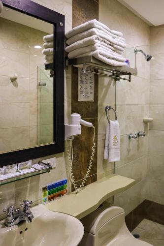 a bathroom with a sink and a mirror and towels at hotel medellin gold in Medellín