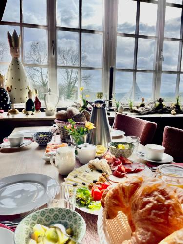 a table with plates of food on a table with windows at Burghaus & Villa Kronenburg in Kronenburg