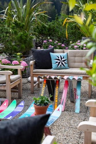 a patio with a couch and surfboards on the ground at Kristiania Lech in Lech am Arlberg